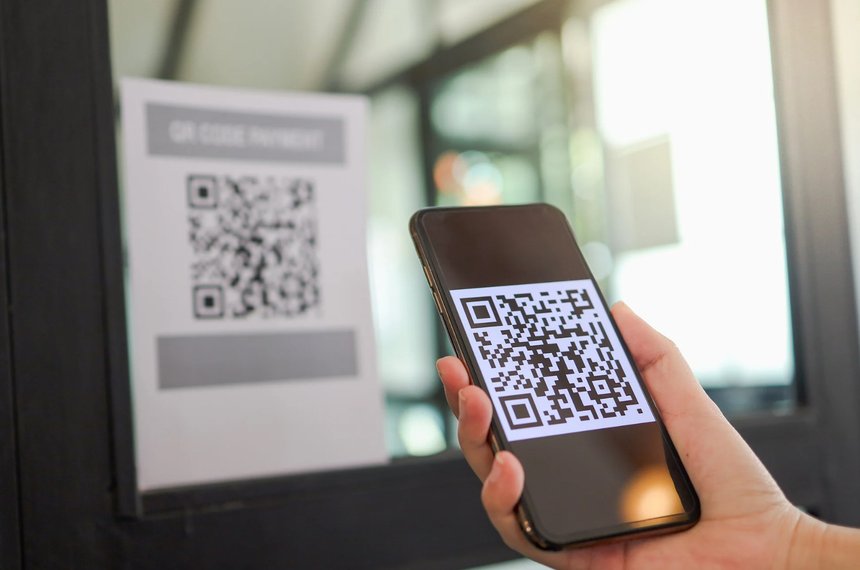 Persona escaneando un código QR en la pantalla de una tablet con la cámara de su teléfono