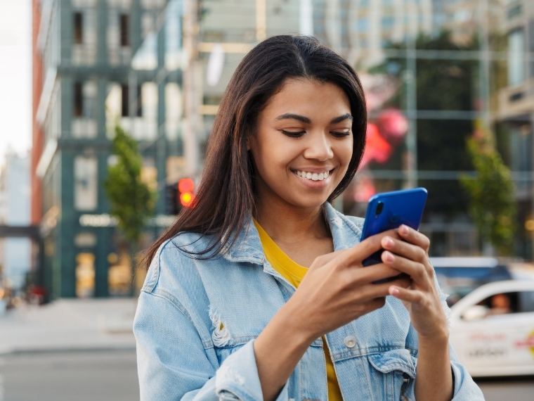Mujer sonriendo mientras instala su eSIM en el teléfono